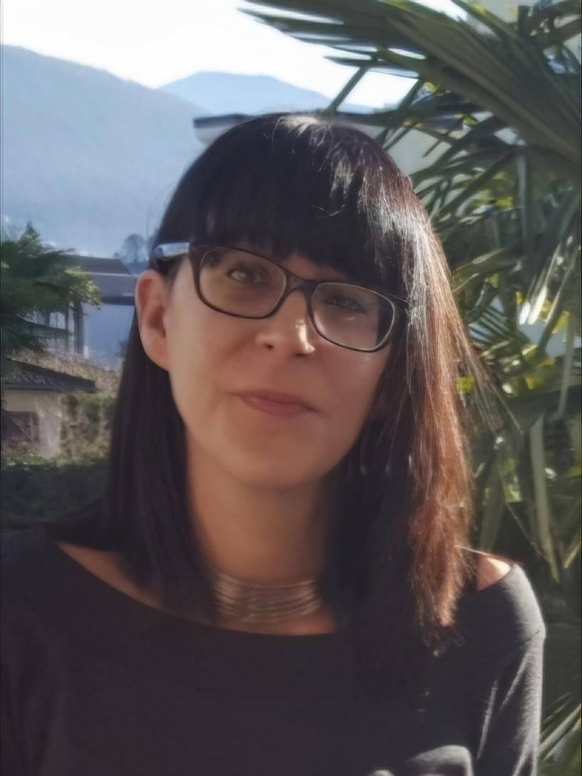 Foto Selbstporträt von Karina Baschong mit offenen dunklen Haaren und Brille