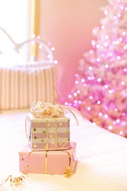 zu sehen ist ein rosa Weihnachtsbaum und ein weißer Bettrahmen, auf dem Bett liegen Geschenke in Pastell