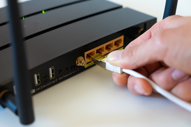 die Rückseite von einem klassischen Modem und einer Hand die ein Kabel einsteckt