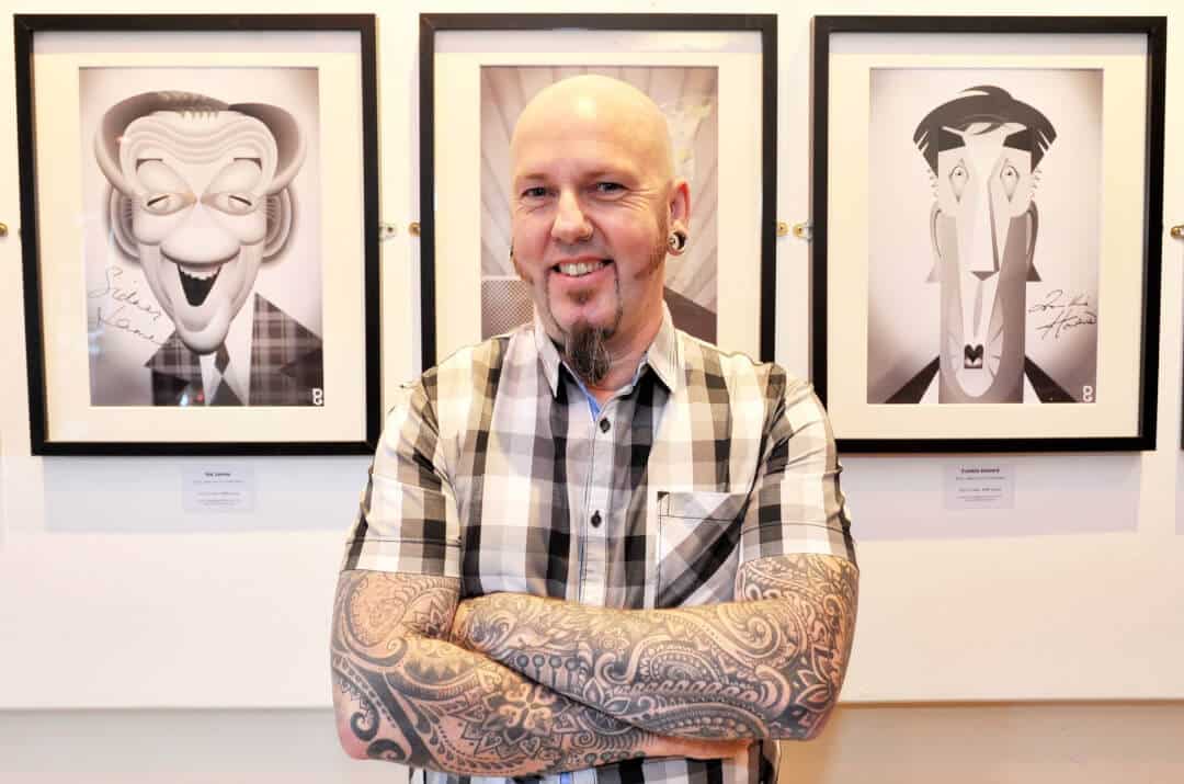 George zwischen zwei sw Zeichnungen in einer Galerie
